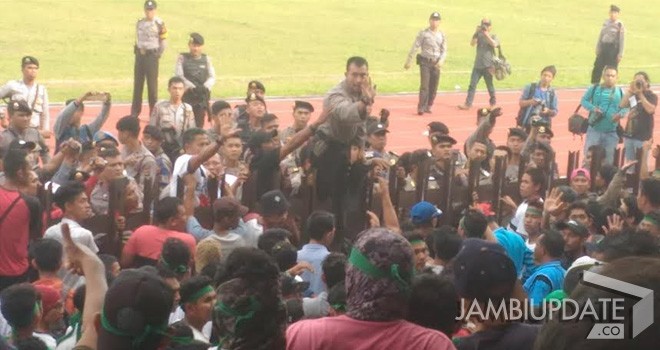 Aparat keamanan mencoba menenangkan penonoton dari masing-masing kesebelasan.