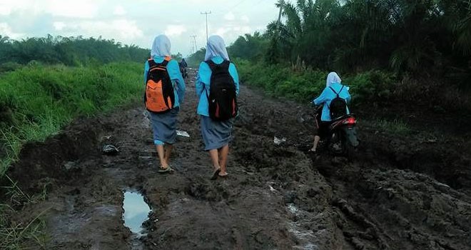 Tampak siswa yang kesulitan saat melintasi jalan.