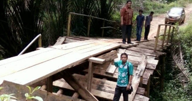Terlihat jembatan di Desa Kemang Manis nyaris putus.
