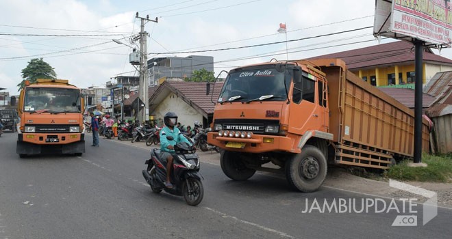 Terlihat satu unit Truk Fuso yang terperosok di depan SDN 84 Kota Jambi. Akibat kejadian ini membuat pagar SD roboh.