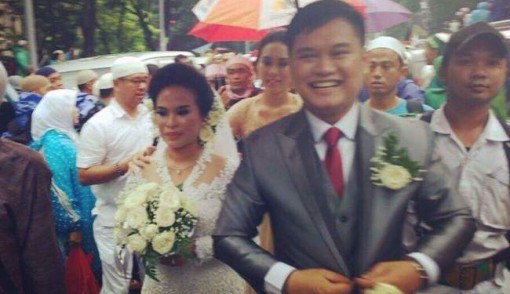 Calon pengantin yang hendak menuju Gereja Katedral Jakarta saat dikawal oleh massa Aksi 112 di seberang Masjid Istiqlal, Sabtu (11/2). Foto-foto: istimewa