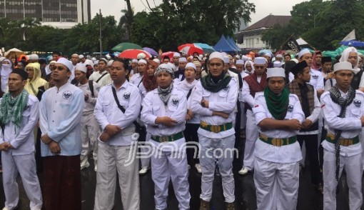 Laskar dari Forum Umat Islam (FUI) berdiri khusyuk mengumandangkan Salawat Badar meski diguyur hujan. Foto: Boy/JPNN.com