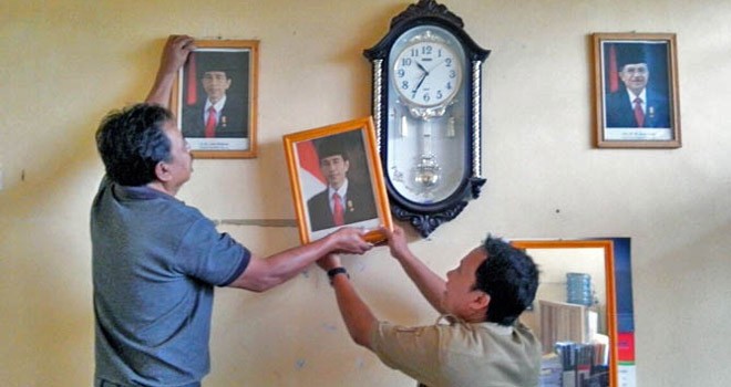 Kepsek SMP N 3 Pangkalan Banteng menurunkam foto presiden berlatar bendera merah dan menggantinya dengan latar bendera merah putih kemarin. (Slamet Harmoko/Radar Sampit)