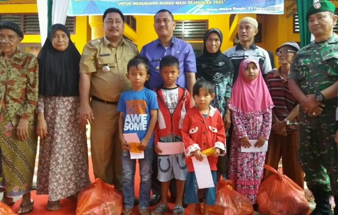 Bupati Muara Bungo, Mashuri saat memberikan paket sembako pada masyarakat.