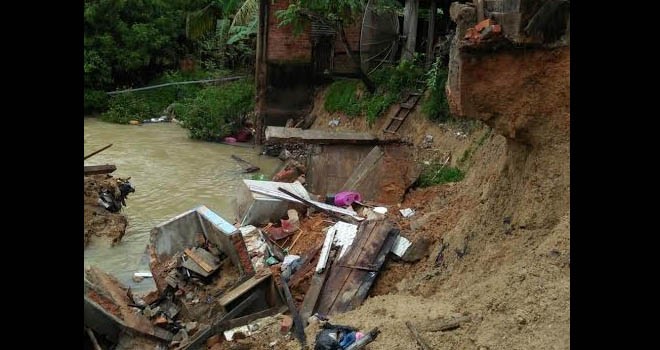 Terlihat bagian rumah warga longsor diterjang banjir.