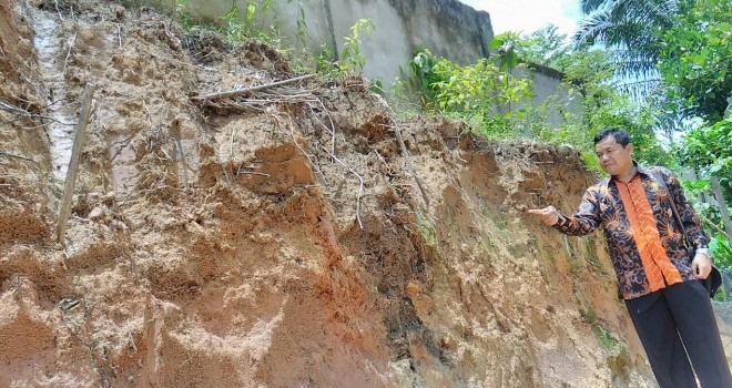 Terlihat kondisi pagar SMPN 22 Kota Jambi yang mau roboh akibat aktivitas pengerukan tanah.