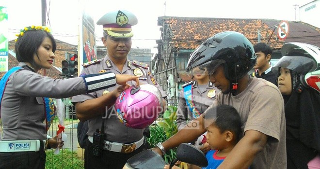 Polwan Polresta Jambi saat memberikan Bunga dan Helm ke Pengendara.