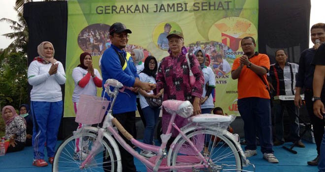 dr H Maulana MKM saat memberikan sepeda kepada Nenek penjual jamu gendong.