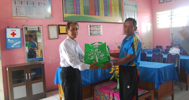 H Erizal, SE humas PT Taspen Cabang Jambi, saat menyerahkan tiket dan kaos senam massal kepada perwakilan sekolah SD N 26 yang diwakili Guru Olahraga, Sumarno.