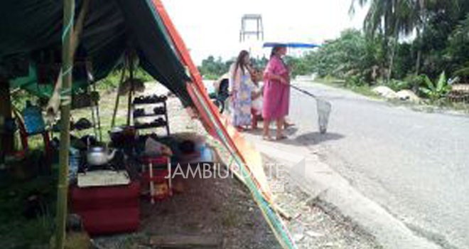 Imbas dari kebun karet terendam banjir, warga Desa Batu Ampar dan Desa Batu Kucing, Kecamatan Pauh , meminta sumbangan di jalan.