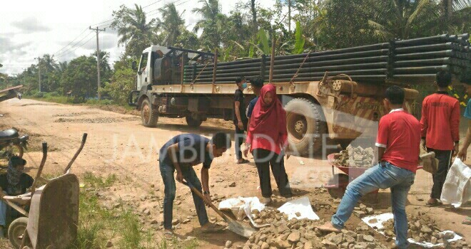 Mahasiswa saat gotong royong memperbaiki jalan di sungai gelam.