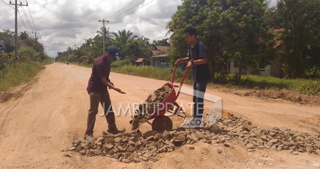 Mahasiswa saat gotong royong memperbaiki jalan di sungai gelam.