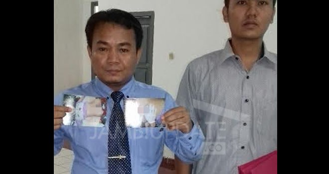 Mudrika SH, MH selaku kuasa hukum pasien saat memperlihatkan gambar kliennya yang mengalami pembengkakan di bagian perutnya.