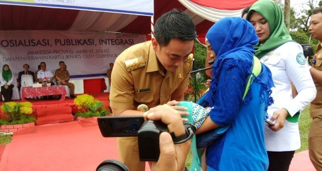 Gubernur Jambi, Zumi Zola memegang salah satu bayi warga pada acara publikasi tentang Integrasi Jaminan Kesehatan Daerah yang bertempat di halaman depan Kantor Gubernur Jambi, Senin (10/4).