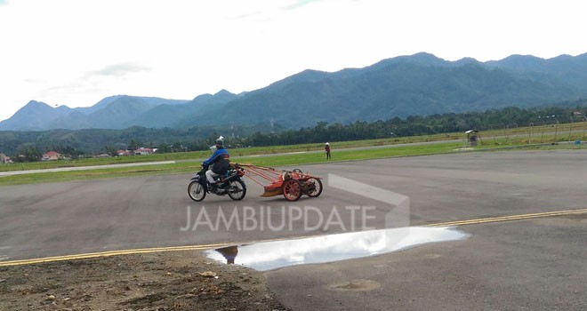 Salah seorang petani padi di Kerinci dengan santainya membawa mesin traktor melintasi runway bandara Depati Parbo Kerinci.