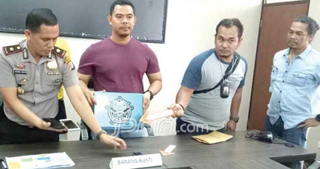 Polisi menunjukkan laptop dan telepon seluler milik tersangka. Perangkat elektronik itu menyimpan ribuan video berkonten pornografi yang diperankan anak-anak dari berbagai negara. Foto: RIFQI/Kaltim Post/JPNN.com
