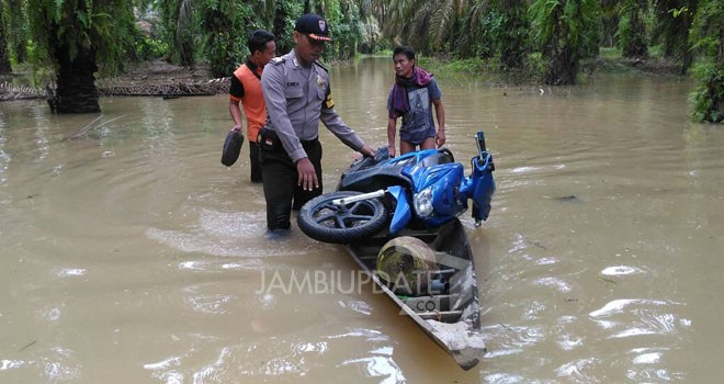 Tampak warga membawa motor dengan menggunakan perahu.