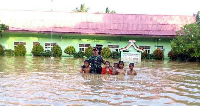 Siswa SD yang akan ujian sekolah terpaksa diungsikan karena banjir menggenangi sekolah mereka.