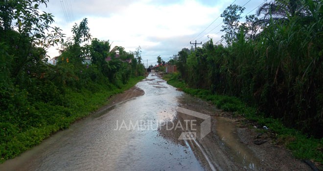 Air meluap menggenangi jalan akibat drainase yang tidak berfungsi di depan pemandian air Panas Desa Sungai Tutung.