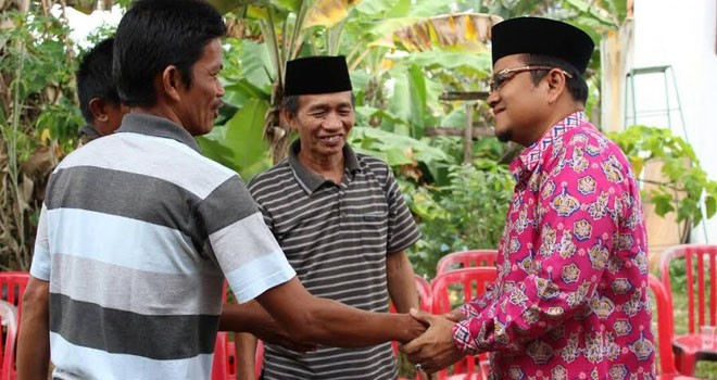 dr. Maulana, SKM sedang bersalaman dengan warga.