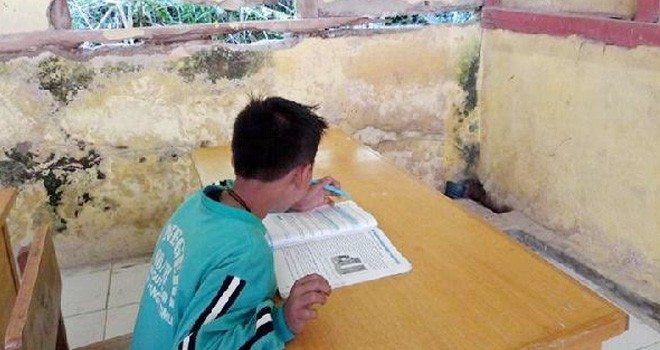Siswa yang sedang belajar tampak terlihat diding SD 80 Pungut Hilir yang telah rusak dan jebol.