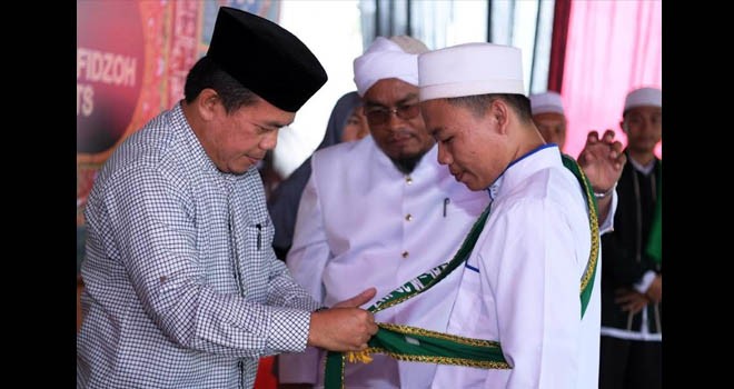 Bupati Merangin H Al Haris memasangkan selimpang kepada salah satu hafidz.