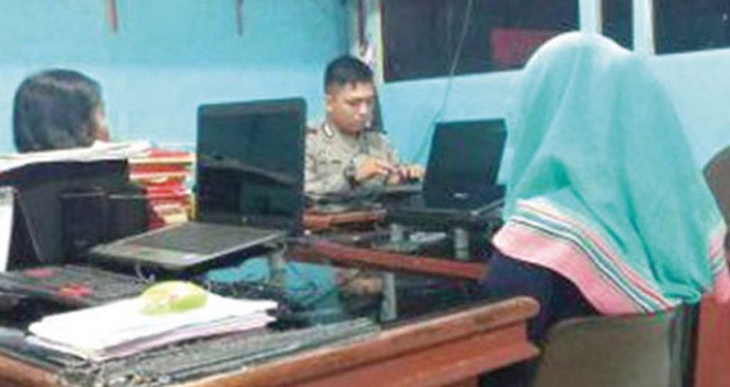 Korban saat melapor ke polisi atas kasus penganiayaan yang dialaminya yang dilatarbelakangi karena rebutan suami. Foto: newtapanuli