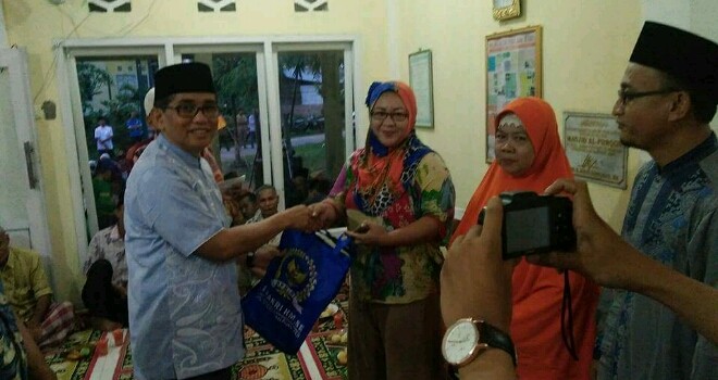 H Bakri saat memberikan sarung kepada warga danau sipin.