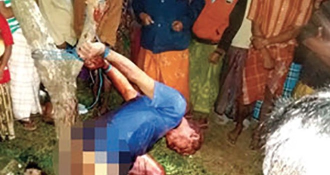 Warga melihat H Umar Fadil yang diikat di pohon mimba di pinggir jalan raya Desa Lapa Taman, Kecamatan Dungkek, Sumenep, dini hari Minggu (18/6). Sekitar pukul 04.40 dia tewas. (ABD. MUKSIDYANTO/JPRM)