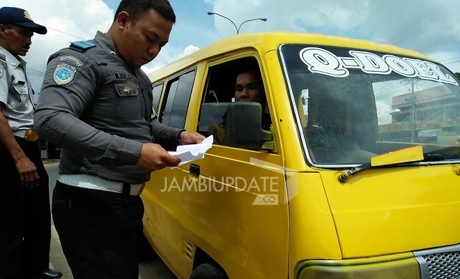 Petugas Dishub Kota Jambi menilang angkot yang ngetem sembarangan. 