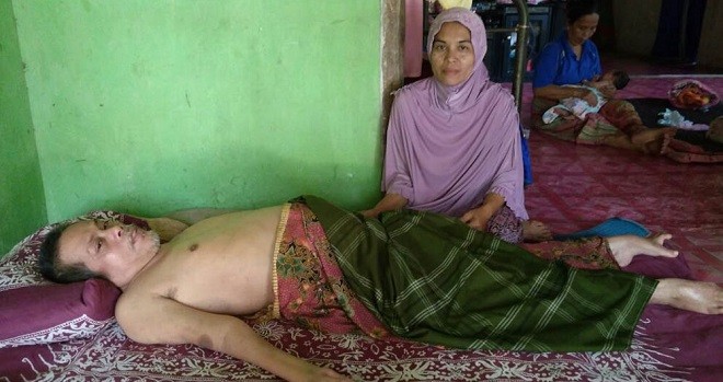 LUMPUH : Saripudin yang terbaring di kasur didampingi istrinya yang dengan sabar merawatnya selama 14 tahun lumpuh.