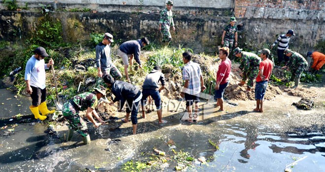 Warga bersama TNI saat bergotongroyong melakukan normalisasi aliran sungai. 