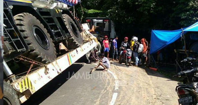 Terlihat mobil tronton yang membawa alat berat terperosok di desa Muara Imat.