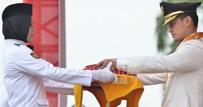 Gubernur Jambi, Zumi Zola menyerahkan bendera duplikat merah putih kepada pembawa baki.