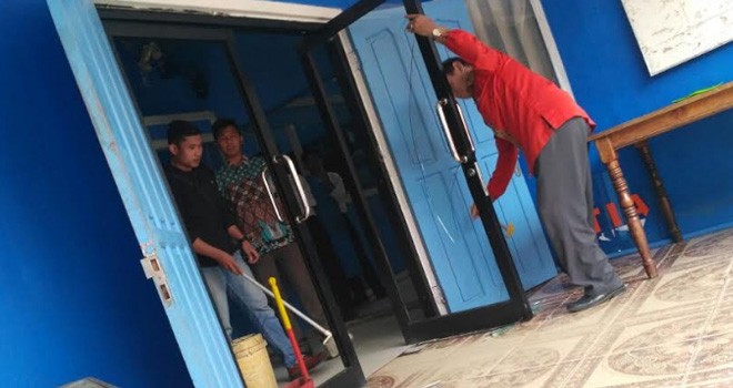 Terlihat pintu kaca ruang ketua yayasan besar yang pecah.
