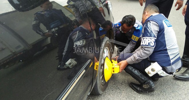 Petugas Dishub Kota Jambi menggembok Kendaraan yang Parkir Sembarangan.