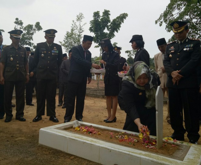 Bupati Muaro Jambi, H. Masnah Busro saat menabur bungan di makam pahlawan.