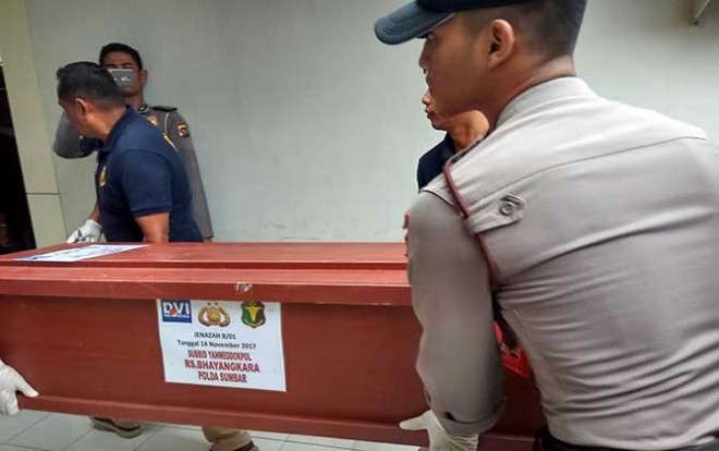 Peti jenazah pelaku pembakar Polres Dharmasraya digotong petugas ke mobil Ambulance untuk di antar ke rumah masing-masing, Selasa (14/21). (Riki Chandra/Jawapos.com)