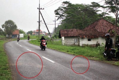 TKP: Lokasi dirampoknya Didik Murtadho dan istrinya di Jalan Raya Desa Pejarakan, Kecamatan Jabon. Sampai Kamis (23/11) sore, bekas darah korban masih membekas di jalan tersebut (lingkaran merah). (Satria Nugraha/Radar Sidoarjo)