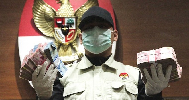 Salah seroang Penyidik KPK saat menunjukan barang bukti berupa uang tunai dari hasil OTT. Foto : JawaPos.com