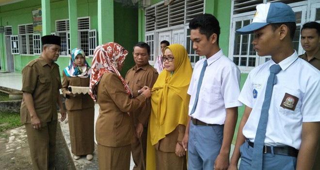 Pemasangan pita hitam kepada guru SMK Satria Kota Jambi yang disaksikan ratusan siswa dan para guru.   