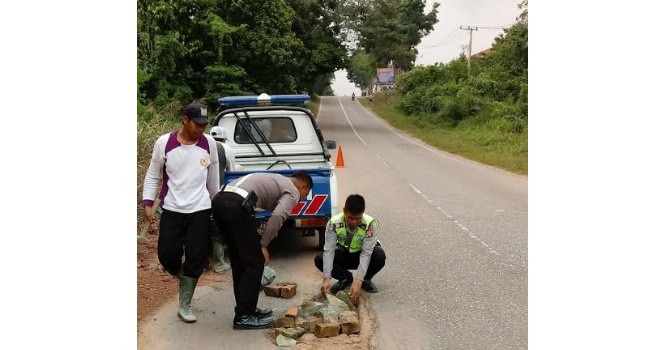 Polres Muarojambi saat menambal Lobang Jalan.