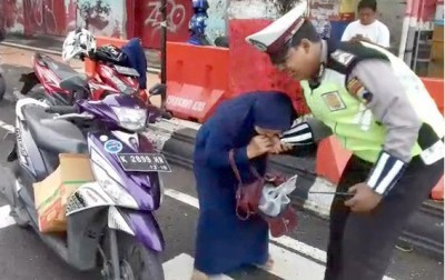 MELAWAN SAAT DITILANG: ATK terlihat menggigit tangan polisi Erlangga Hanando Seto dalam video yang viral kemarin. (RADAR KUDUS PHOTO VIA VIDEO WARGA)