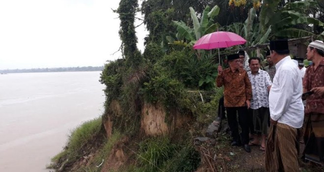 Bakri Gunakan Payung Tinjau Rencana Pembangunan Turap di Jaluko.