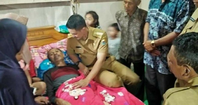 Gubernur Jambi, H. Zumi Zola Zulkifli saat mengunjungi Sagiyanto (47), warga Desa Gunung Labu, Kecamatan Kayu Aro Barat, yang menderita kanker otak. 