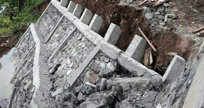 Terlihat tembok penahan jalan yang ambruk.