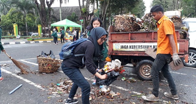 Petugas Kebersihan dan masyarakat komunitas peduli sampah membersihkan sampah di tengah Kota Jambi pada peringatan Hari Peduli Sampah Nasional. 