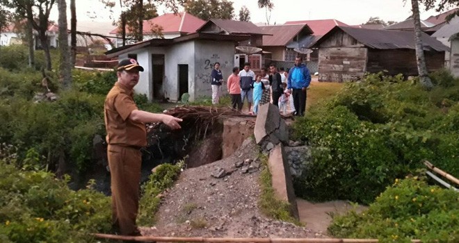 Terlihat kepala BPBD saat meninjau jembatan yang putus.