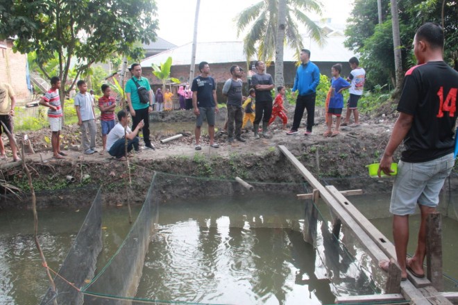 Fasha melihat kolam ikan warga di Suka Karya