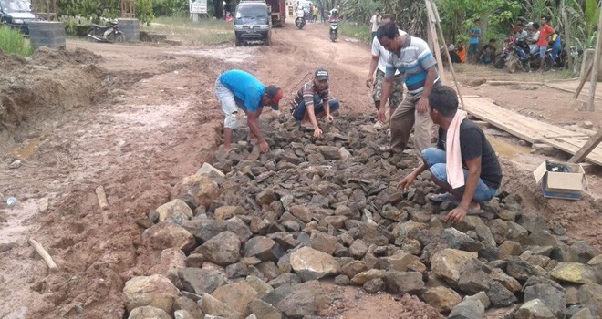 Warga saat ikut memperbaiki Jalan Tangkit.